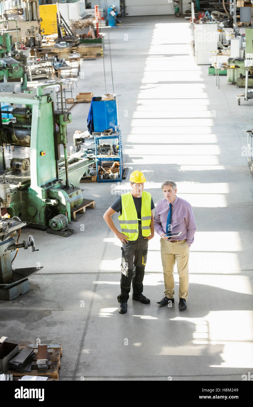 High angle view of supervisor and manual worker having discussion in metal industry Stock Photo