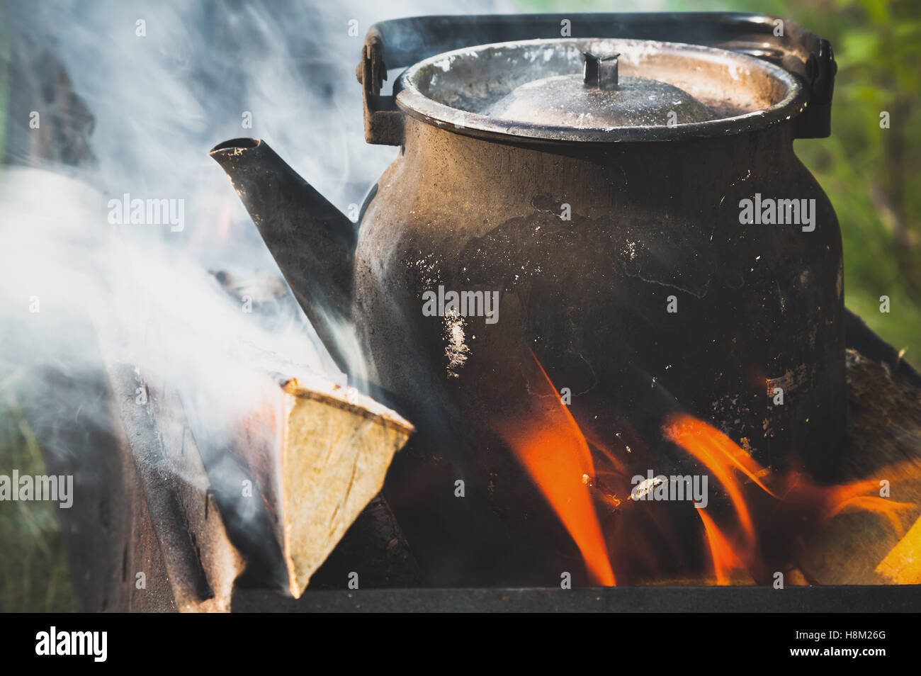 Old used black boiling teapot stands on a bonfire Stock Photo Alamy