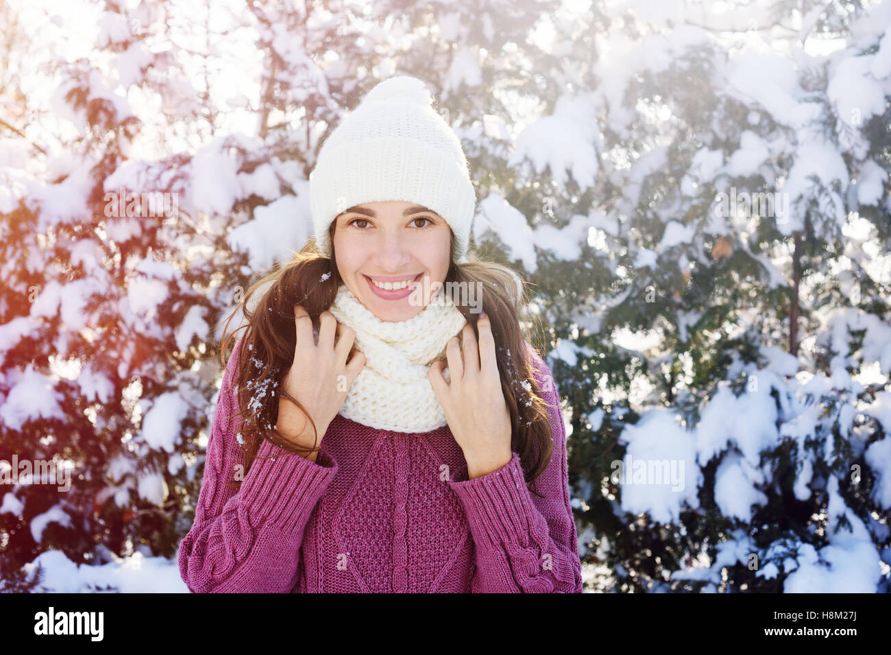 happy young woman in a white knitted hat and scarf in Winter Park Stock Photo