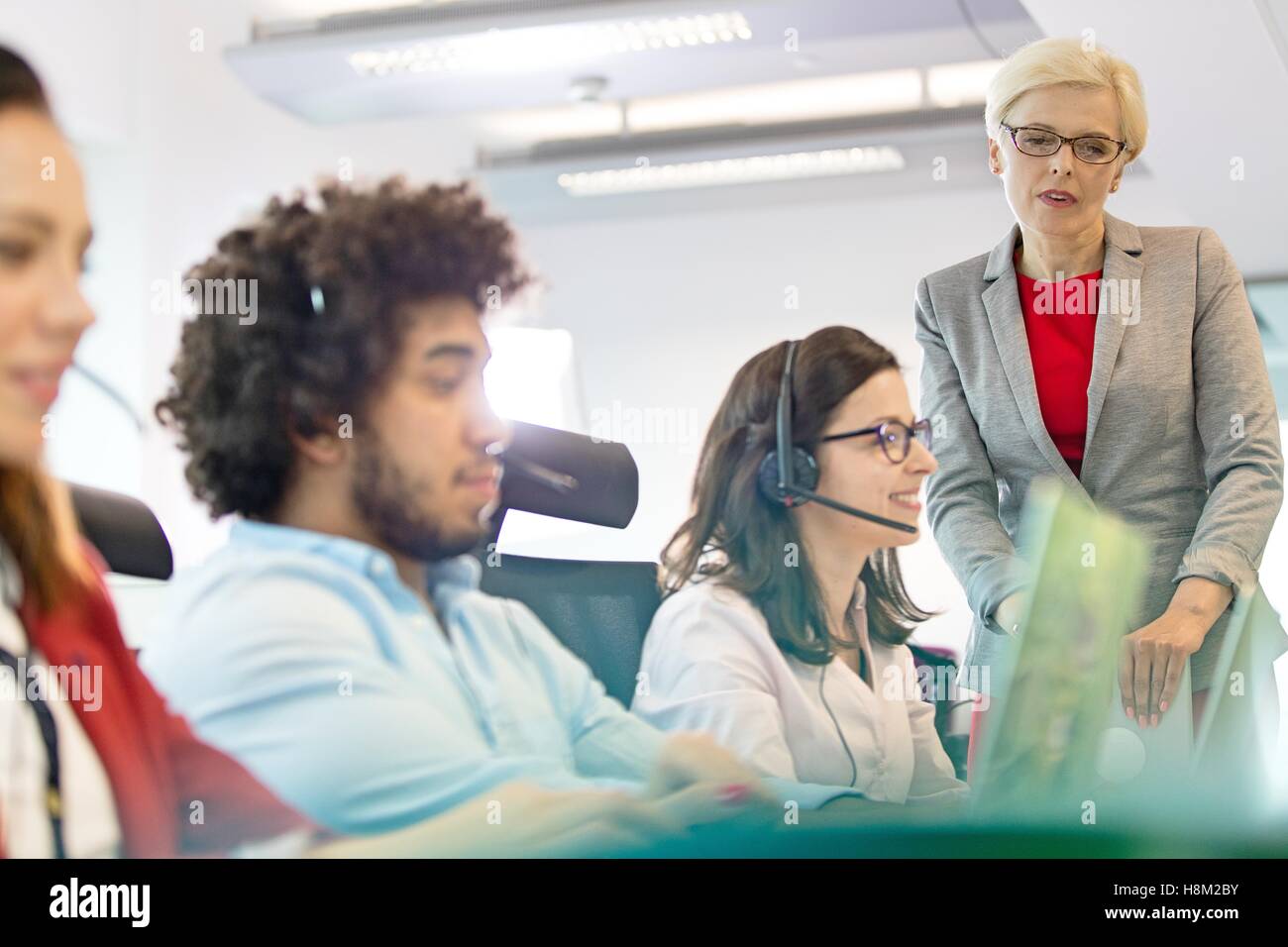 Mature businesswoman with operators working in office Stock Photo