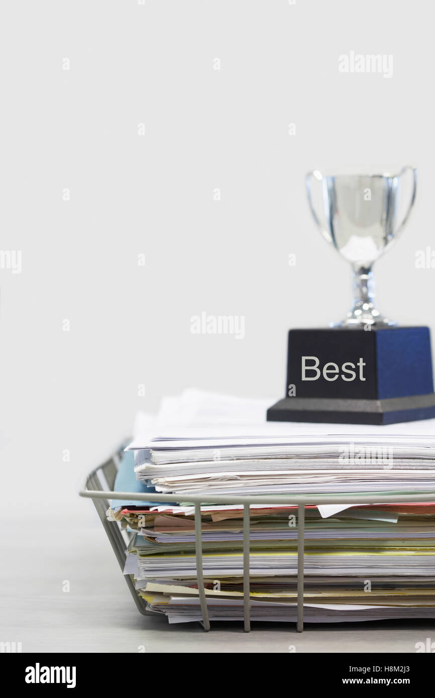 Trophy on Top of Papers saying best Stock Photo