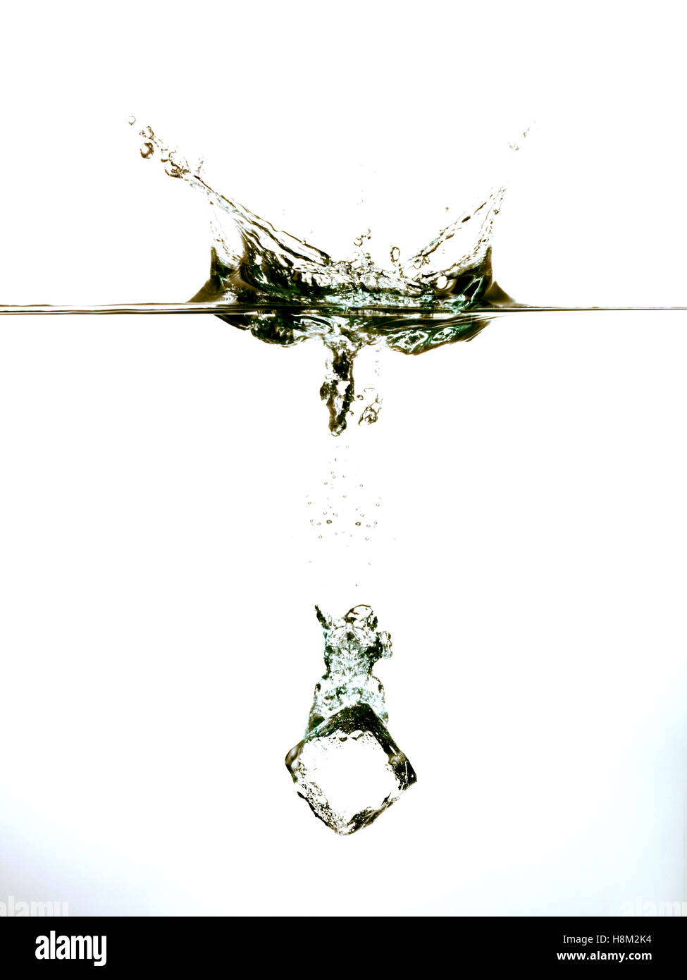 Ice cube splashing into clear water surface view Stock Photo - Alamy
