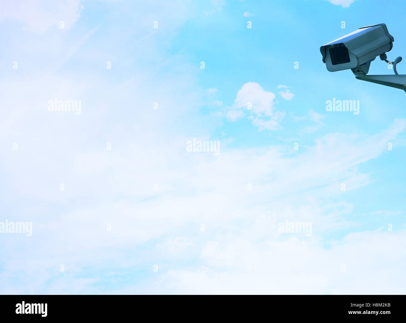 Security camera on wall against clouds Stock Photo