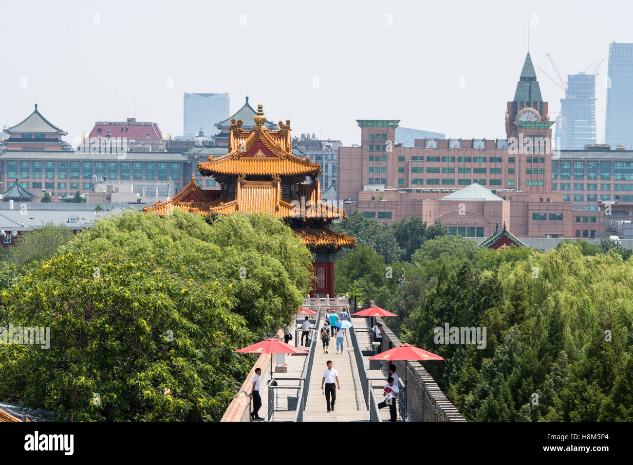 Beijing China - Tourists walking and taking pictures in the Forbidden City. The modern day city of Beijing is in the background. Stock Photo