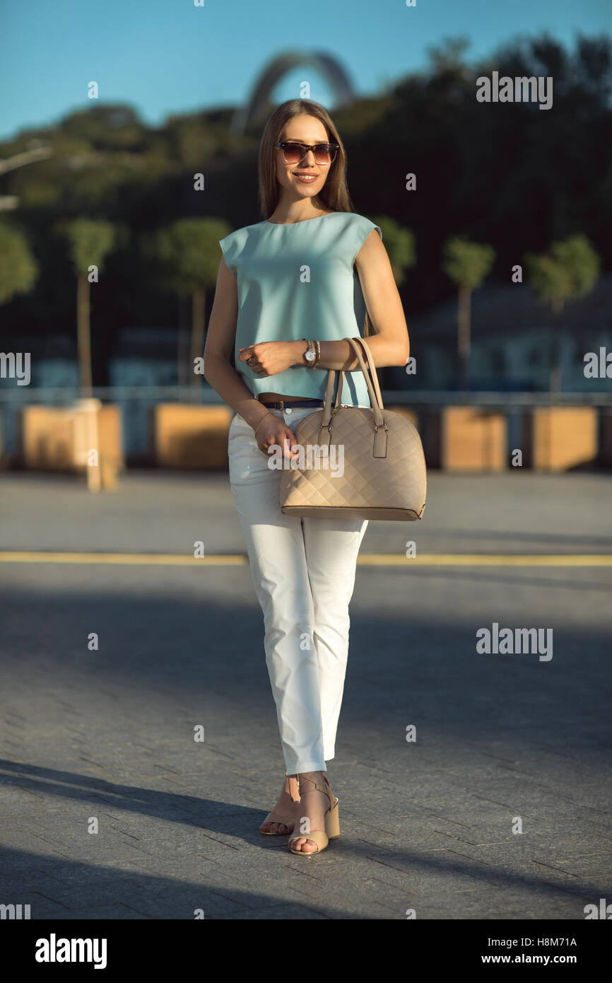 young business woman wearing sunglasses standing on the street Stock Photo
