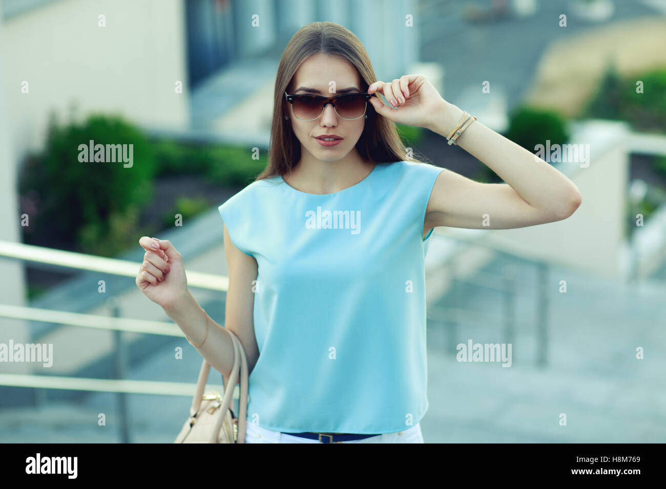 Young fashion business woman in sunglasses on a city street. Stock Photo