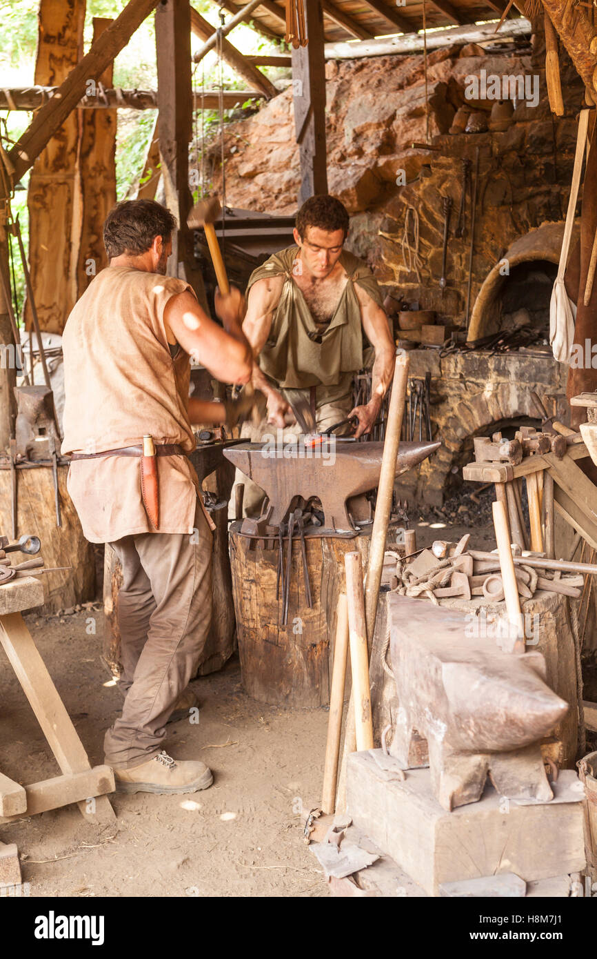 Blacksmiths working on iron at the medieval works of Guedelon. Stock Photo