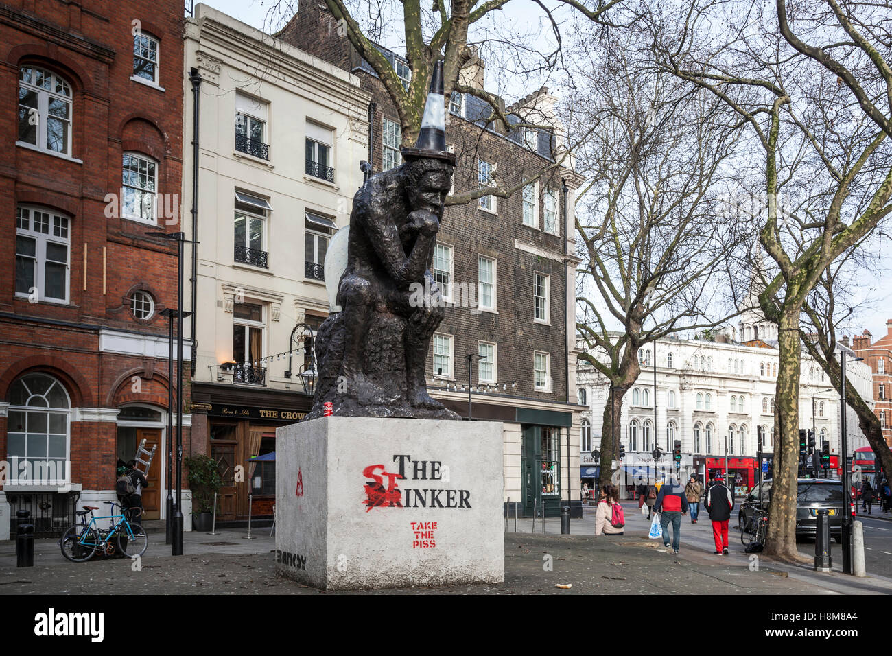 'The Drinker' a sculpture by Banksy, now amended by the artist AK47 and renamed 'The Stinker' in Shaftesbury Avenue. London. Stock Photo