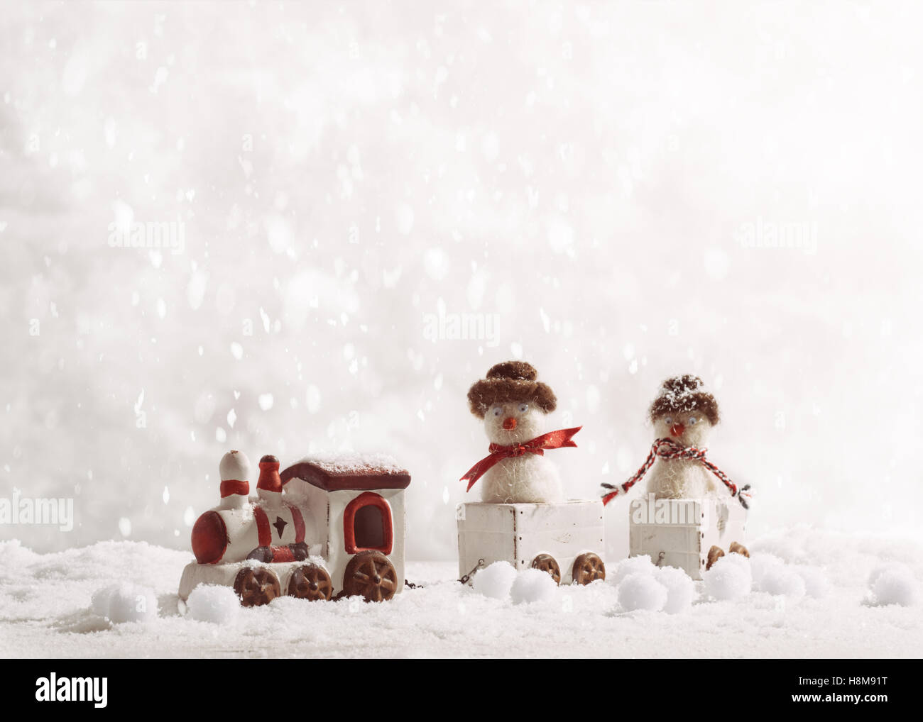 Toy train set carrying snowmen in winter setting Stock Photo