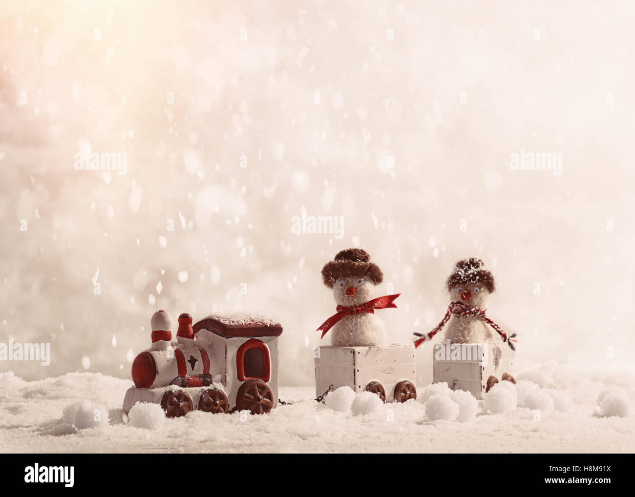 Snowmen sitting in toy train set at Christmas in the snow Stock Photo