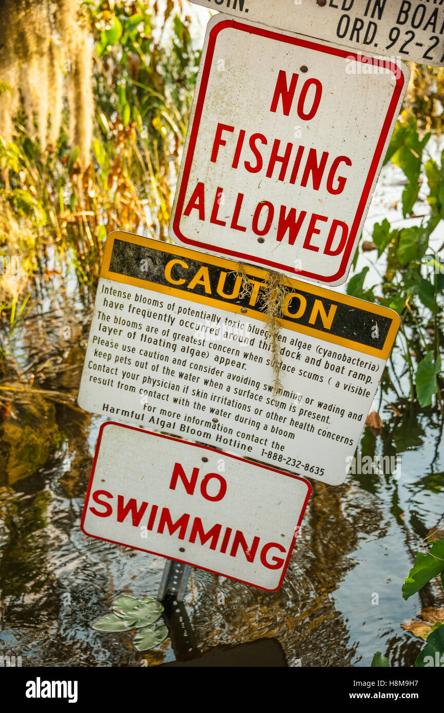 Warning signs near a boat ramp on Lake Harris in Leesburg, Florida, USA