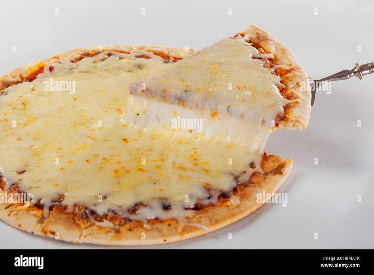 Lifting a pizza slice with melted mozzarrella cheese dripping. Stock Photo