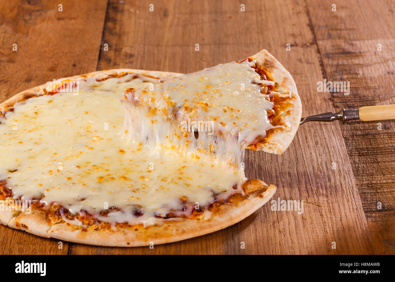 A slice of hot pizza just from the oven with melted cheese dripping
