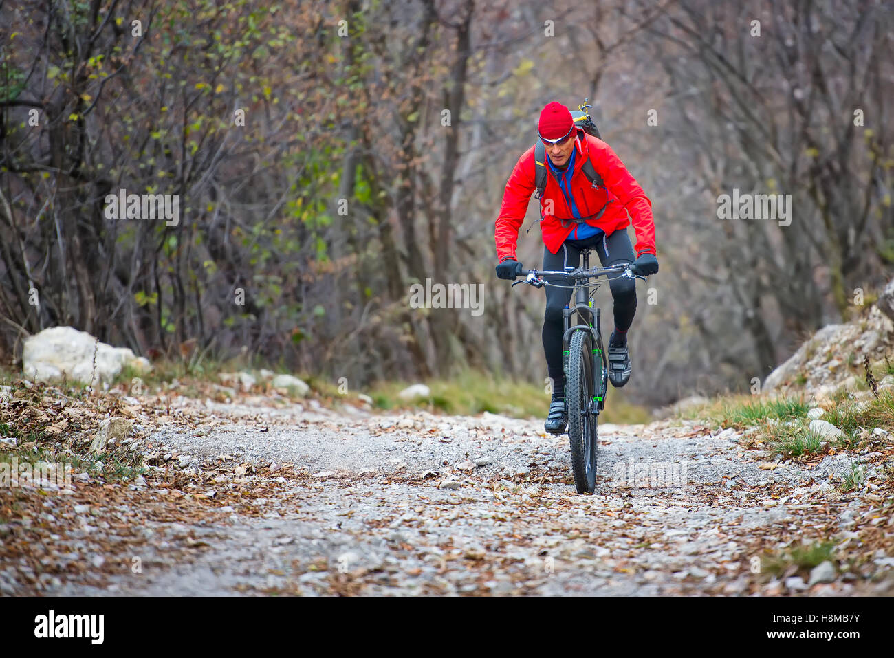 Biker with mountain bike on dirt road in autumn Stock Photo Alamy