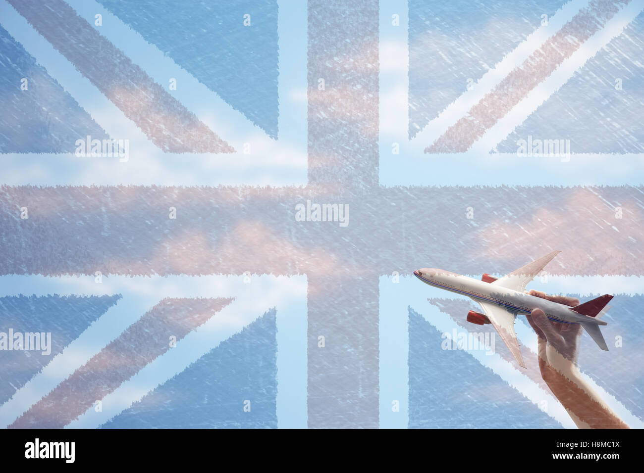 Toy plane flying in front of Union Jack flag Stock Photo