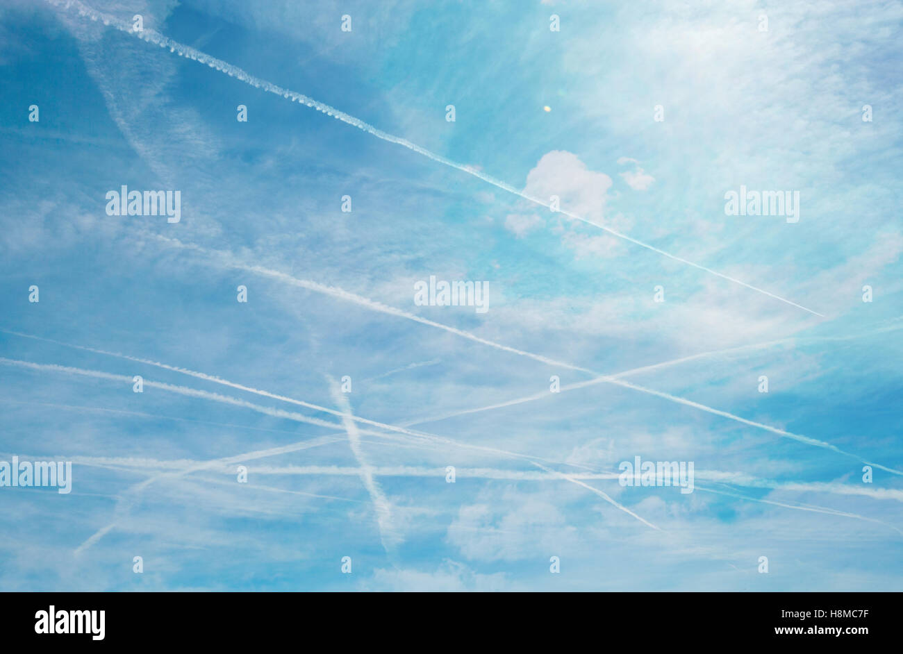 Cross contrails over blue sky background Stock Photo