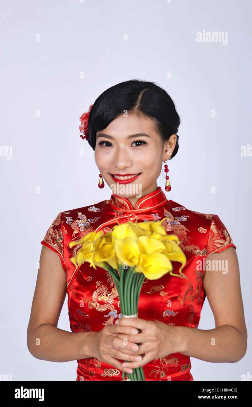 pretty chinese young woman holding a bunch of yellow daffodils Stock Photo