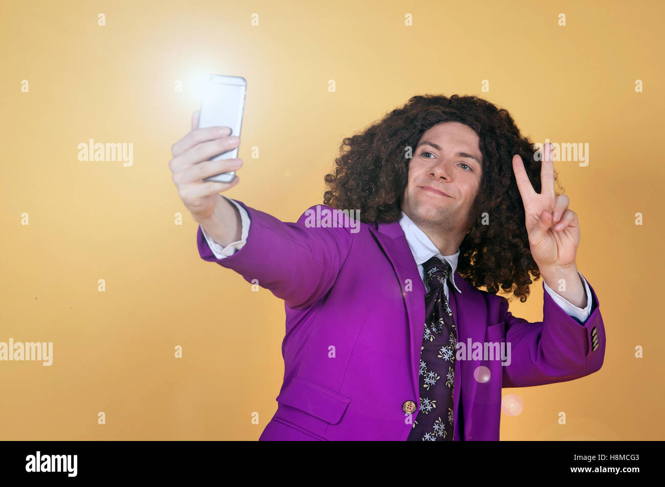 Caucasian man with afro wearing Purple Suit taking a selfie Stock Photo