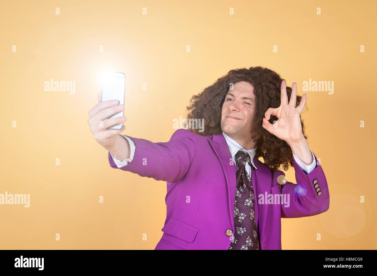 Caucasian man with afro wearing Purple Suit taking a selfie Stock Photo