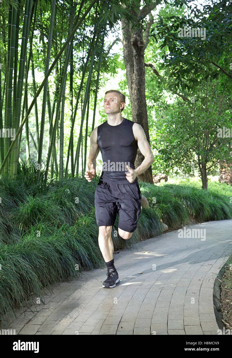 Fit and Healthy Caucasian man running in park Stock Photo