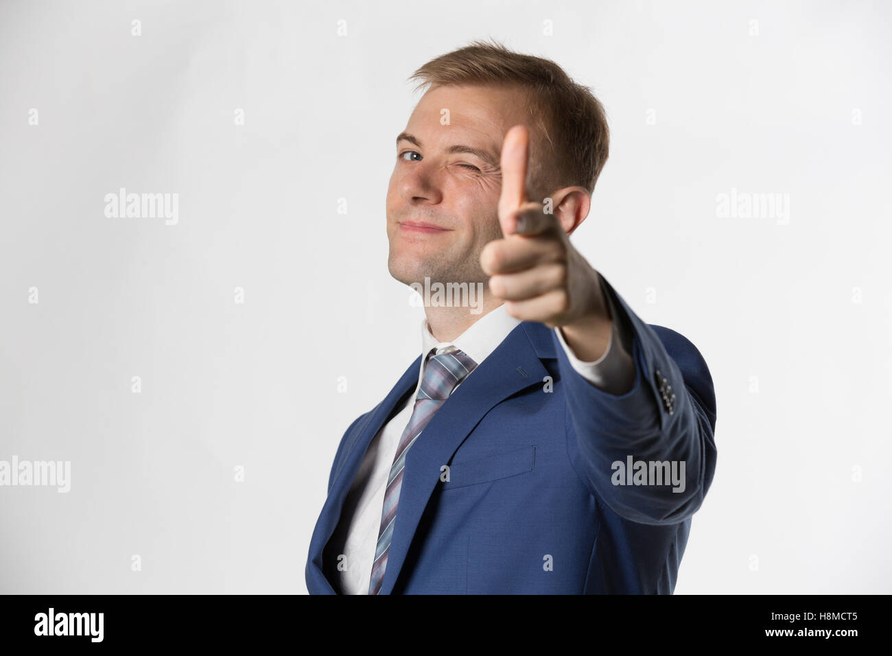 Businessman winking and pointing to camera Stock Photo