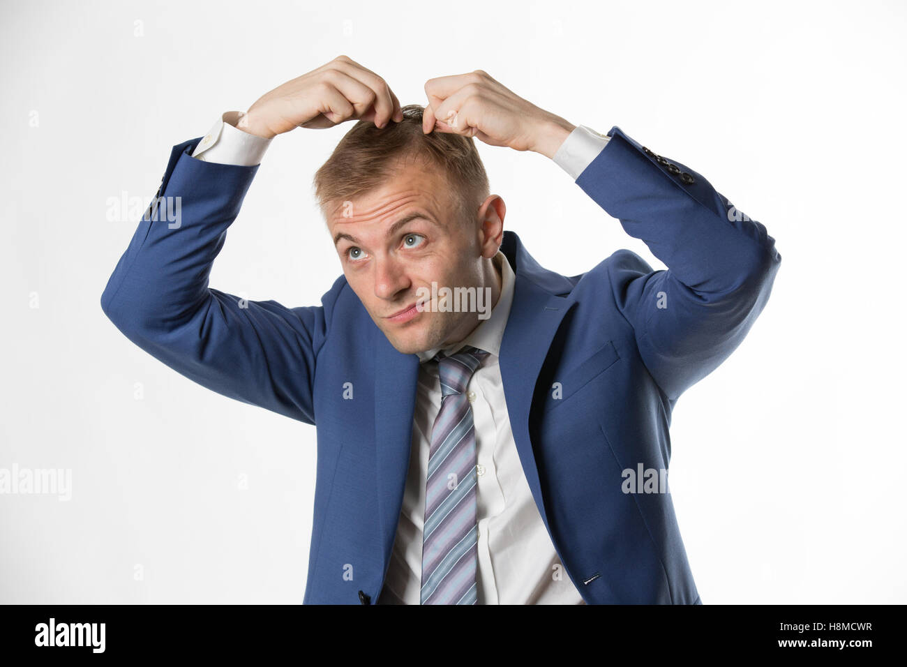Businessman checking his hair indicating hair loss Stock Photo