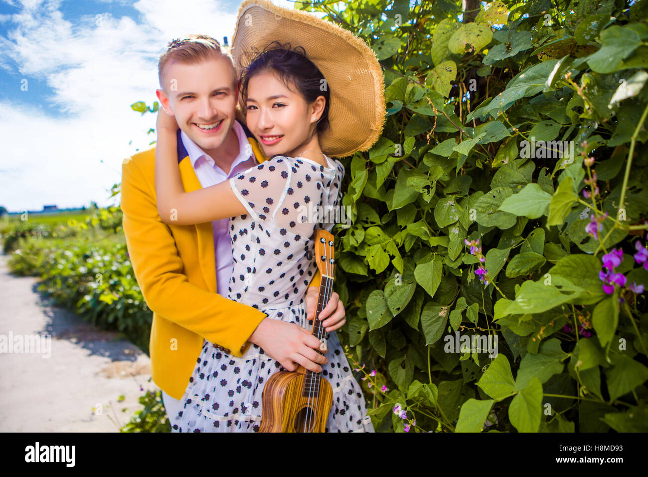 Portrait of happy couple embracing by plants Stock Photo
