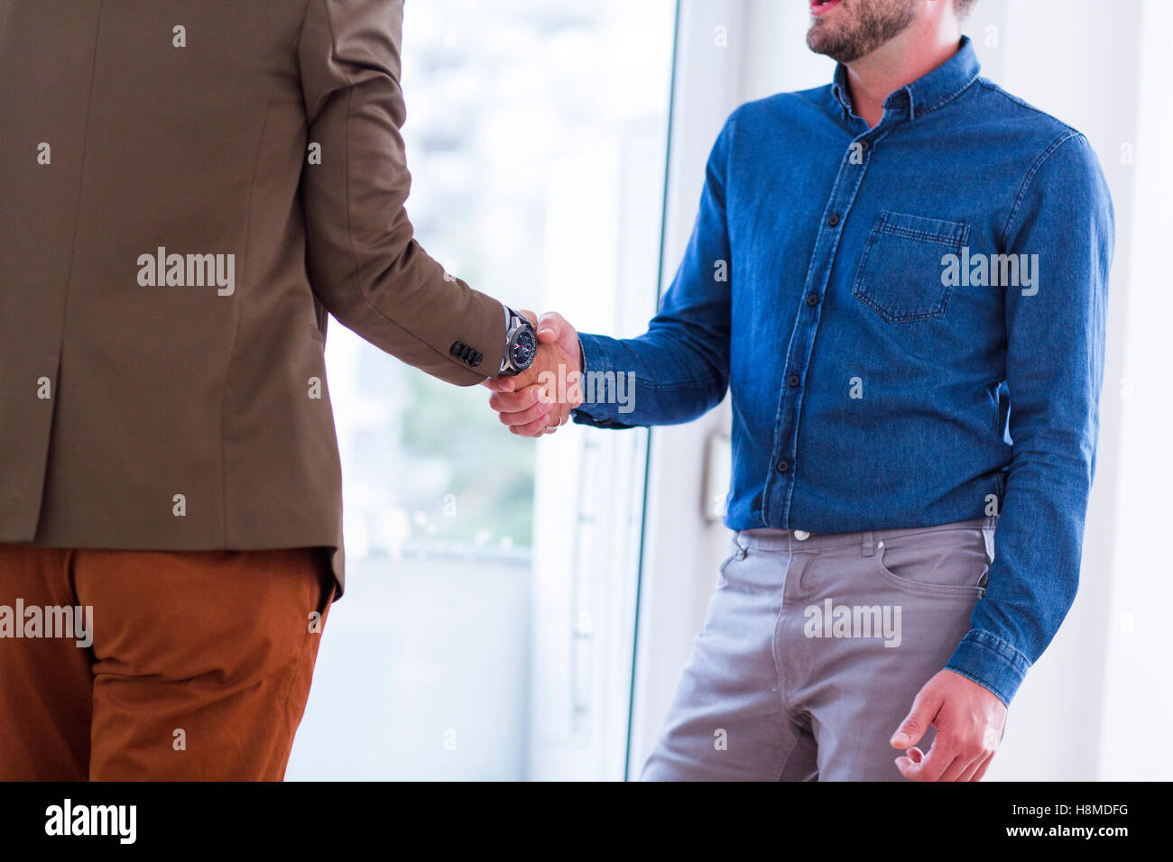 Man and Woman shaking hands in office Stock Photo