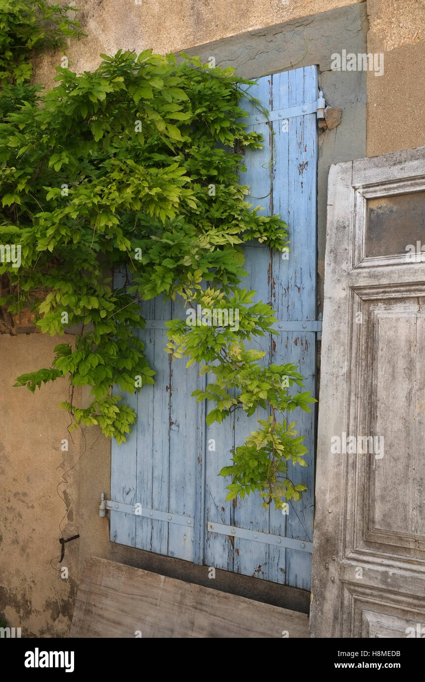 old character french architecture detail including a worn blue shutter in south west france Stock Photo