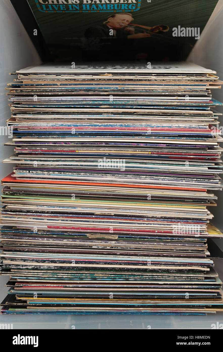 Stack or pile of numerous LP records in a plastic storage box giving a pleasing subtle old fashioned yet fashionable on trend concept Stock Photo