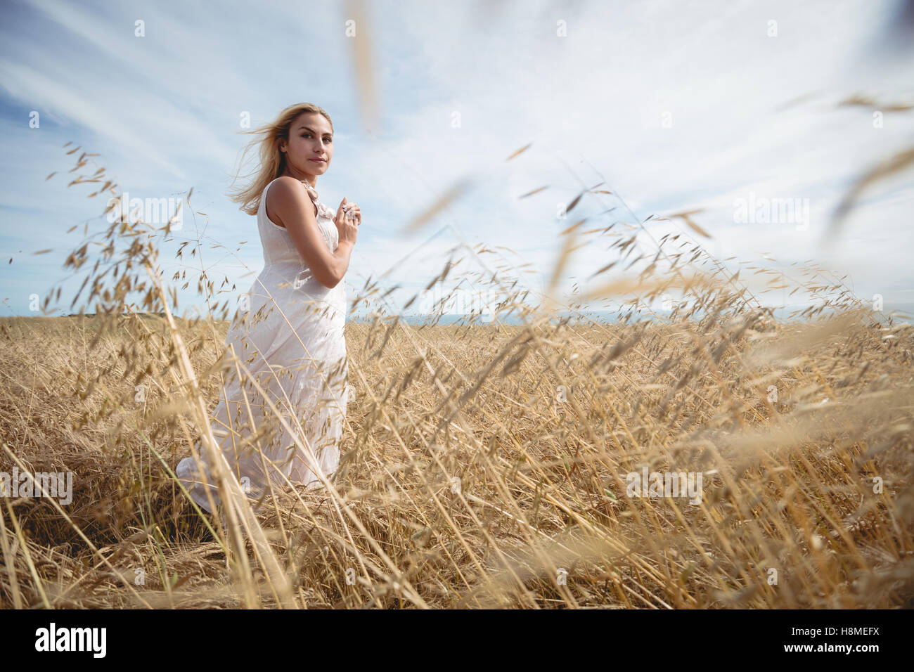 Blonde woman standing in field Stock Photo - Alamy
