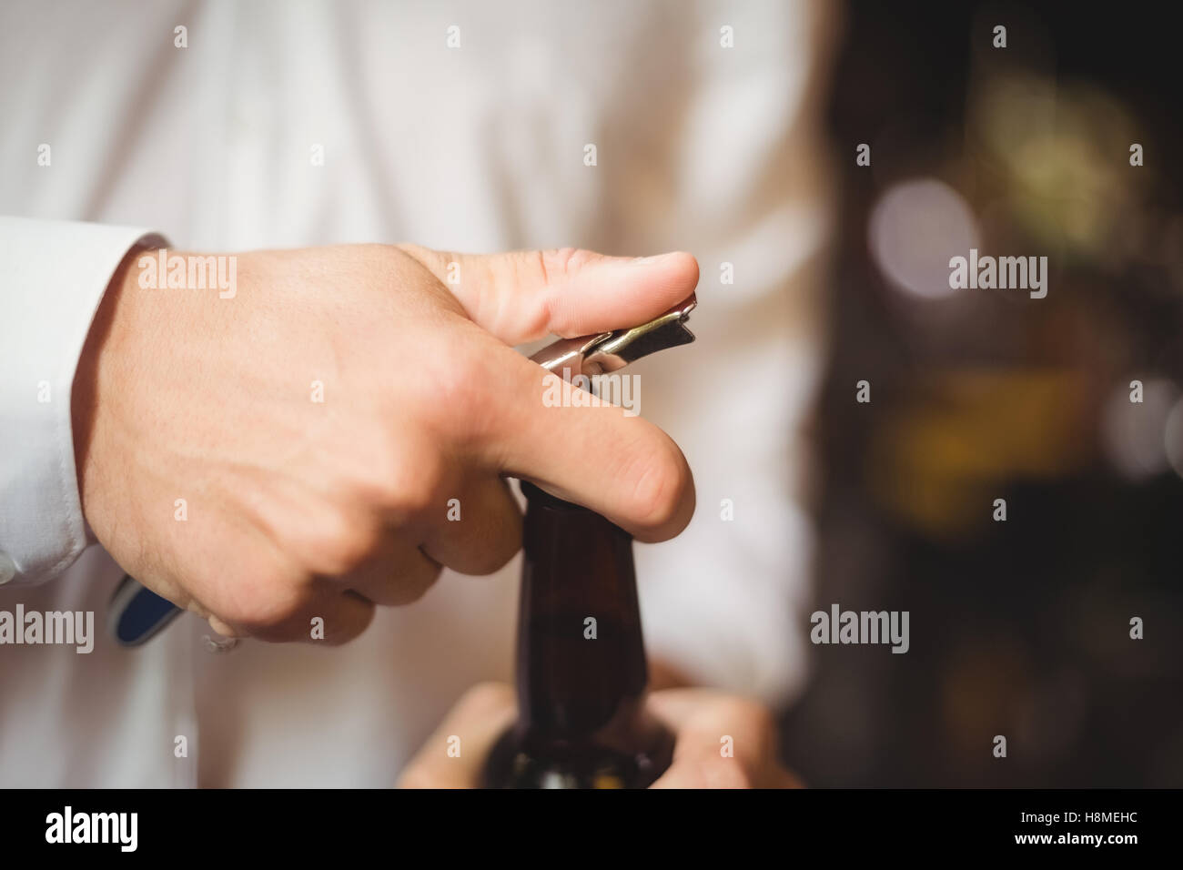 Close-up of bartender opening a beer bottle Stock Photo