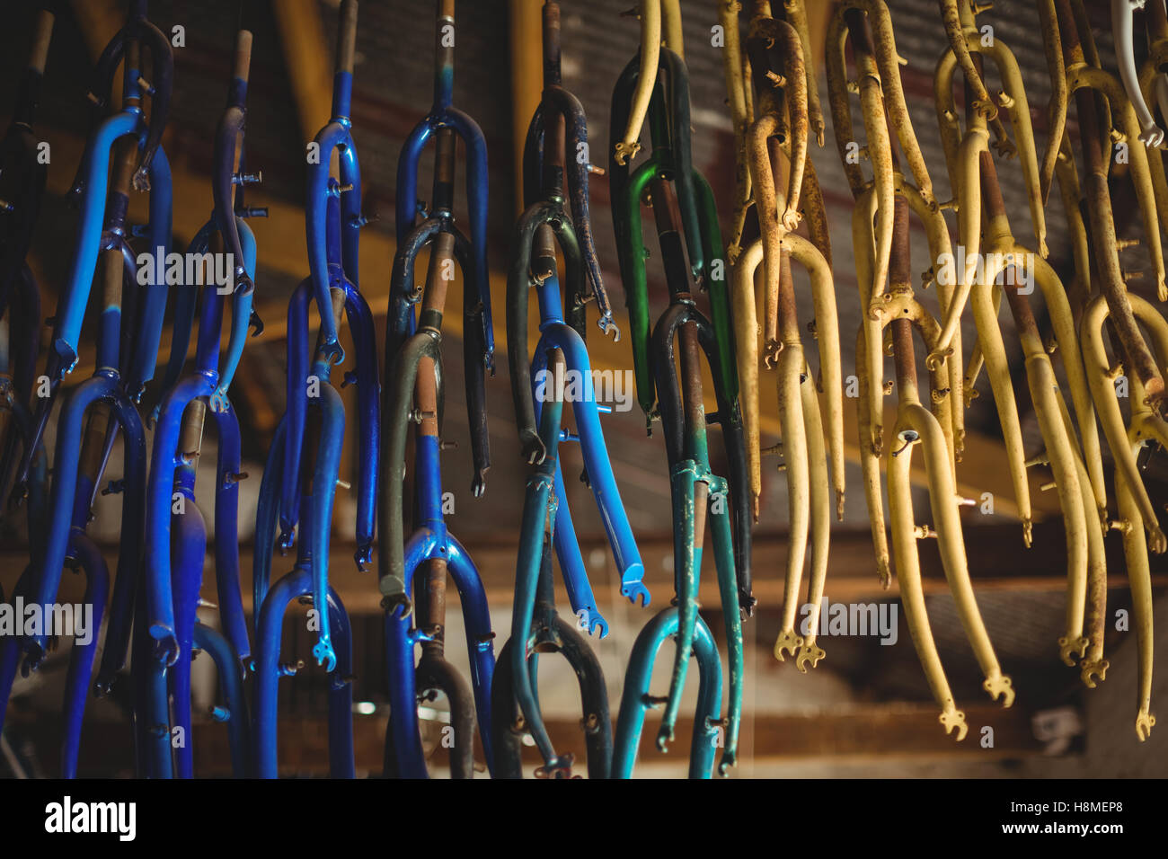 Close-up of multicolor bicycle handle bars hanging on ceiling Stock Photo