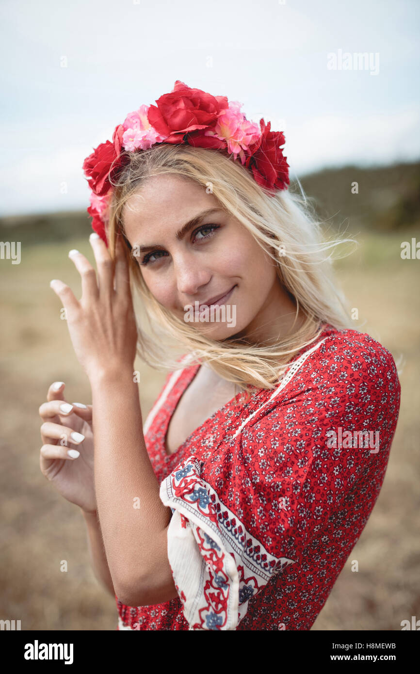 Blonde woman wearing a flower tiara standing in field Stock Photo