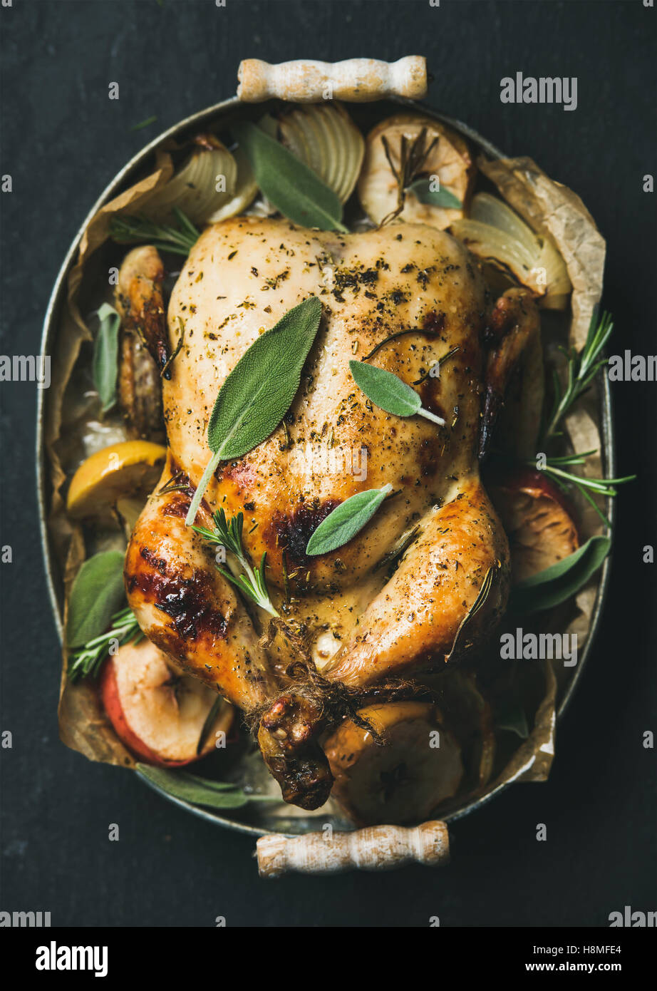 Oven roasted whole chicken with apples, onion and sage Stock Photo
