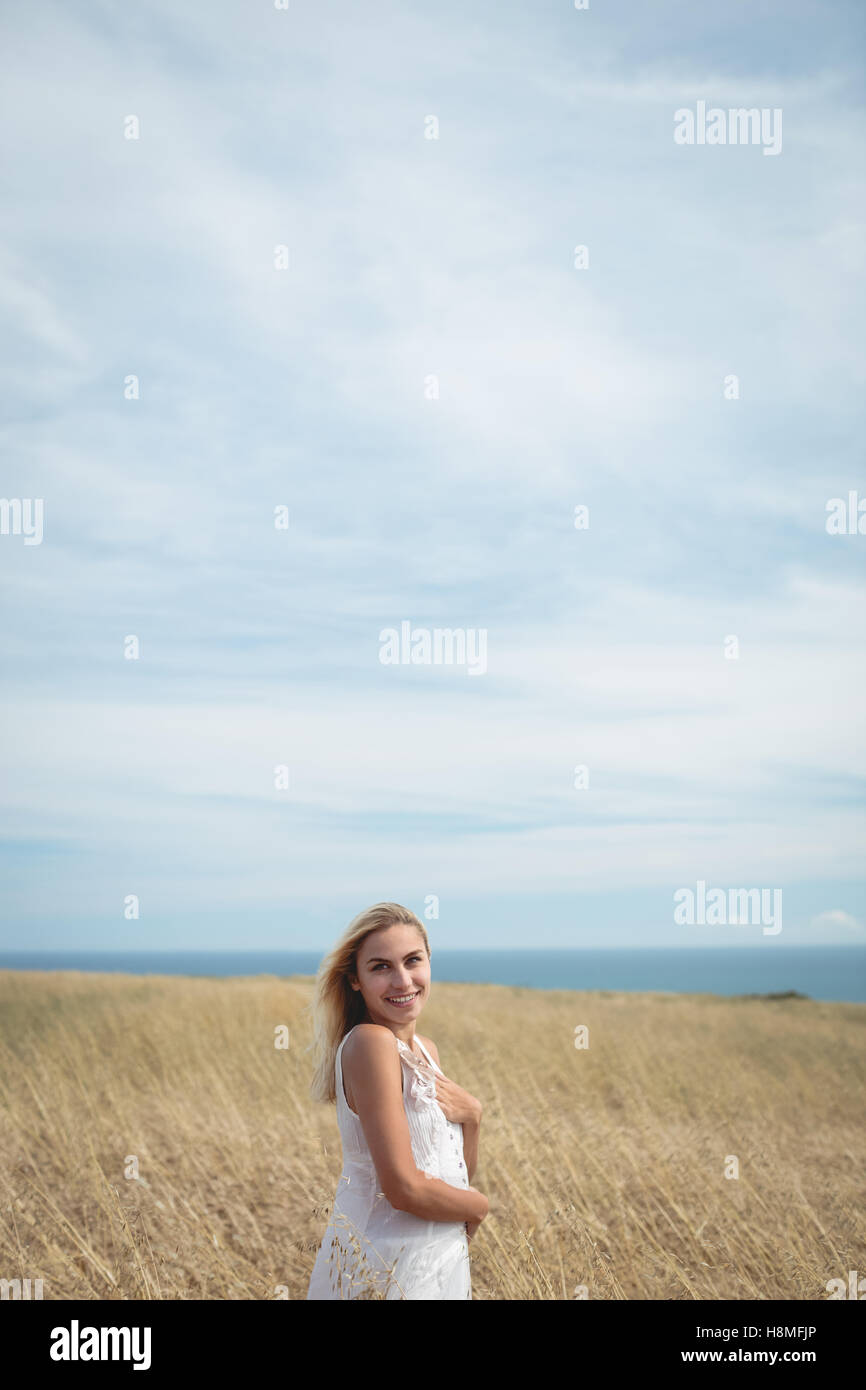 Smiling blonde woman standing in field Stock Photo - Alamy