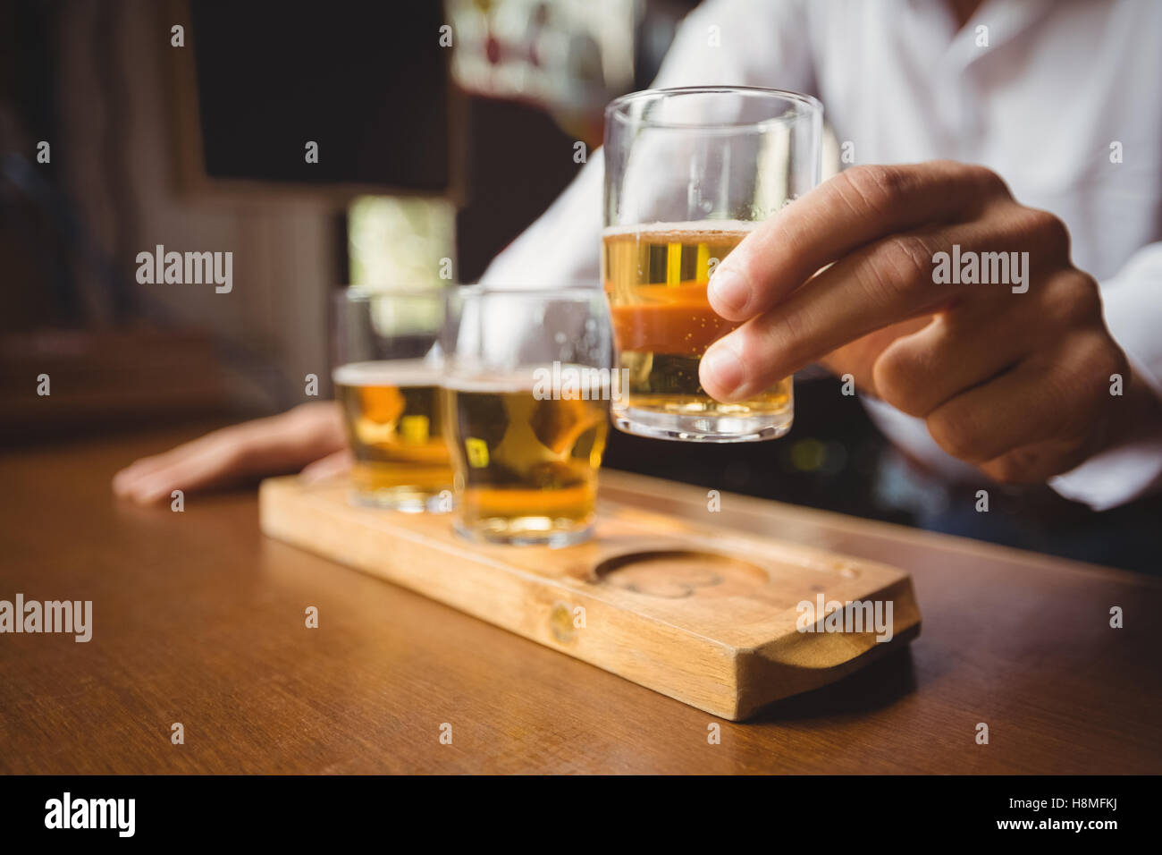 Close-up of bartender holding whisky shot glass at bar counter Stock Photo