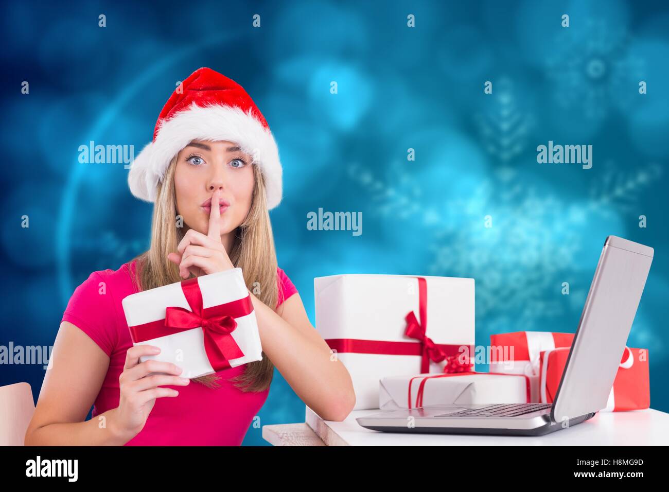 Woman with finger on lip holding christmas gift during christmas time Stock Photo