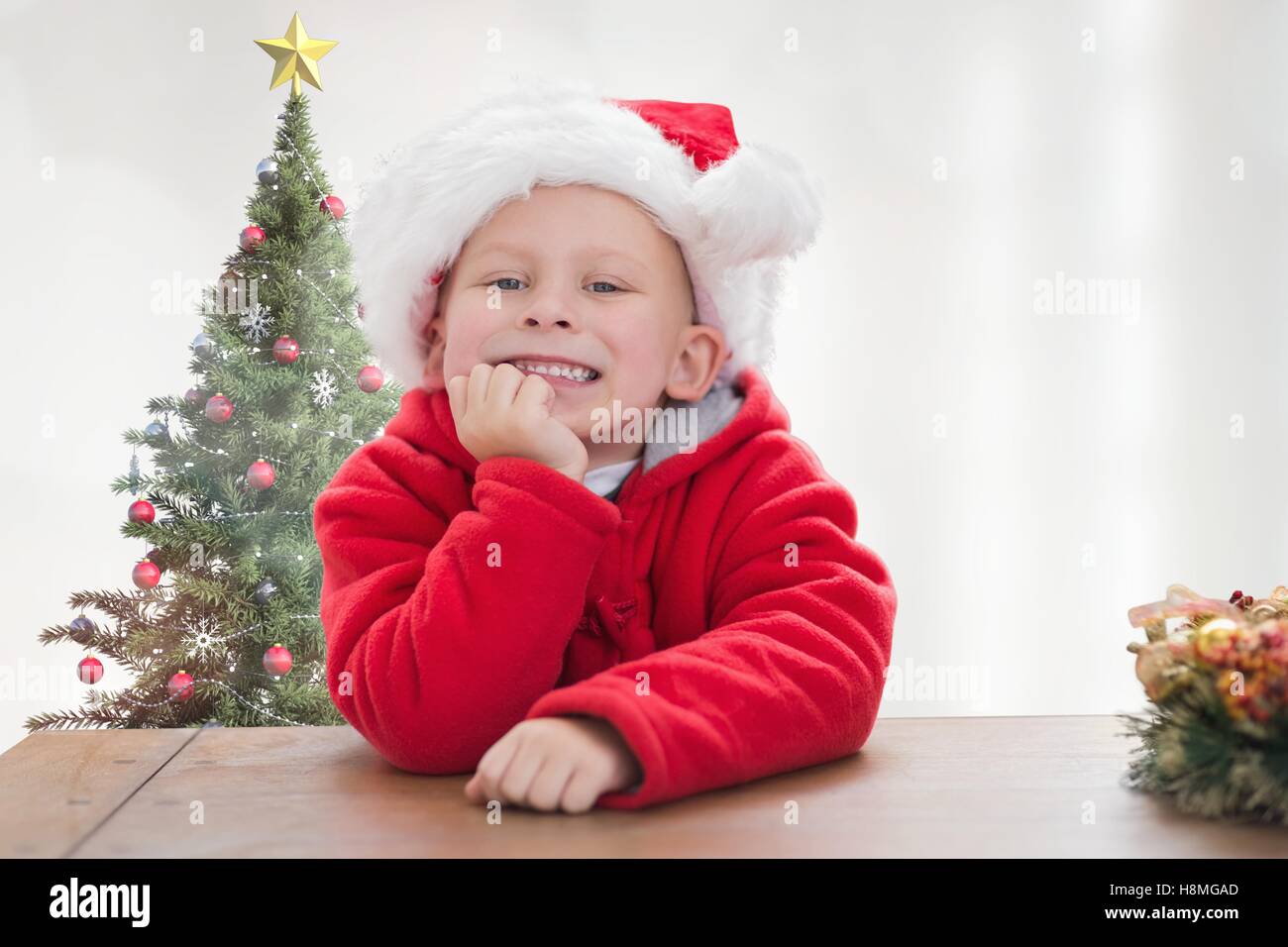 Portrait of smiling boy in santa costume leaning on table Stock Photo