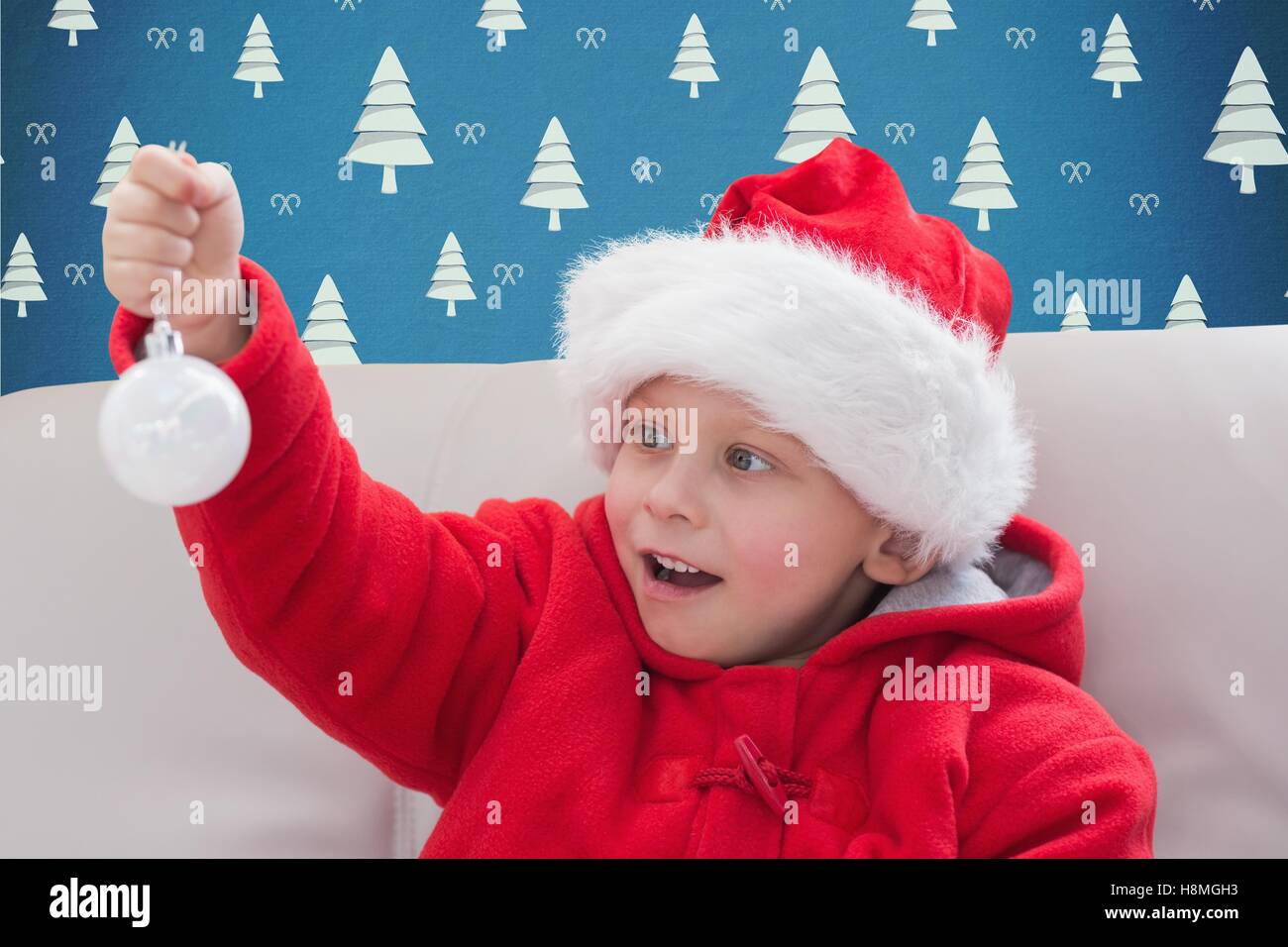 Little boy in santa hat holding a bauble Stock Photo