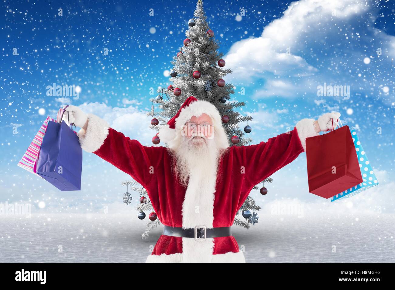 Santa claus holding christmas gift bags Stock Photo - Alamy