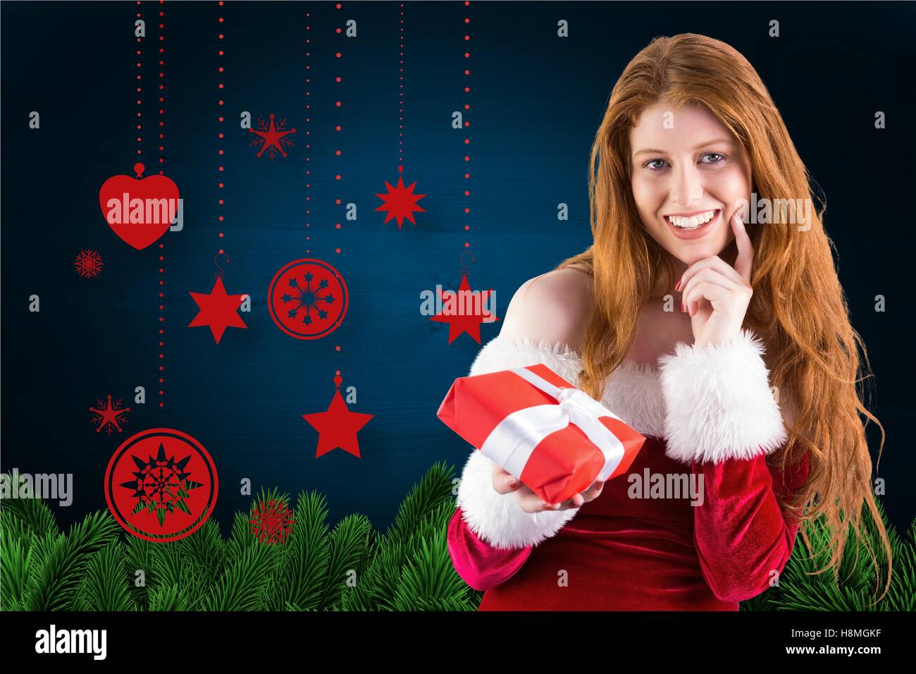 Beautiful woman in santa costume holding a christmas gift Stock Photo
