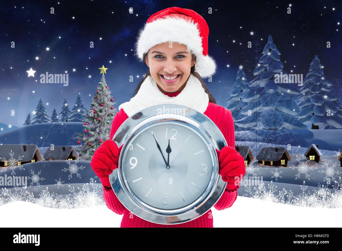 Happy woman in santa hat holding a wall clock Stock Photo - Alamy