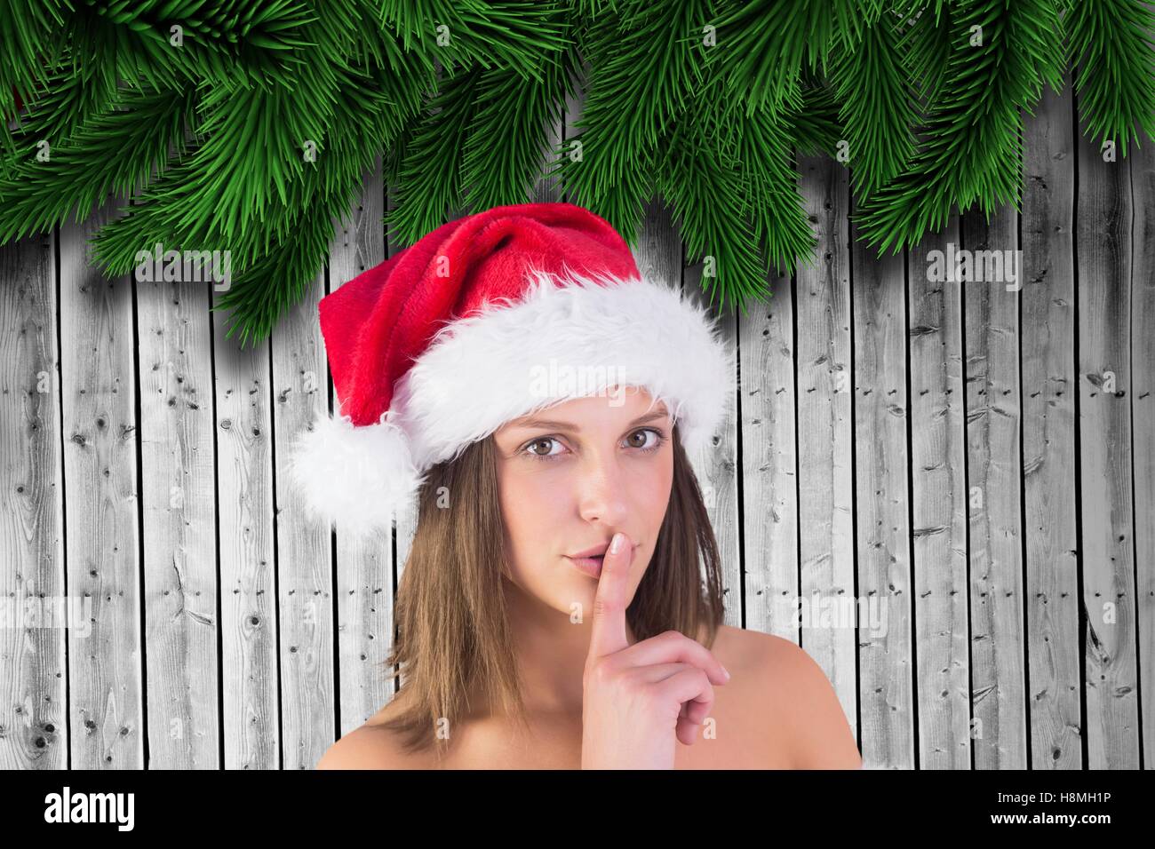 Portrait of beautiful woman in santa hat with finger on lips Stock Photo