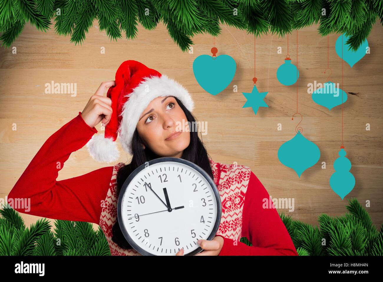 Thoughtful woman in santa hat holding clock Stock Photo