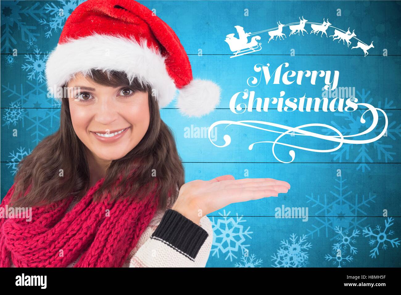 Beautiful woman in santa hat gesturing against digitally generated background Stock Photo