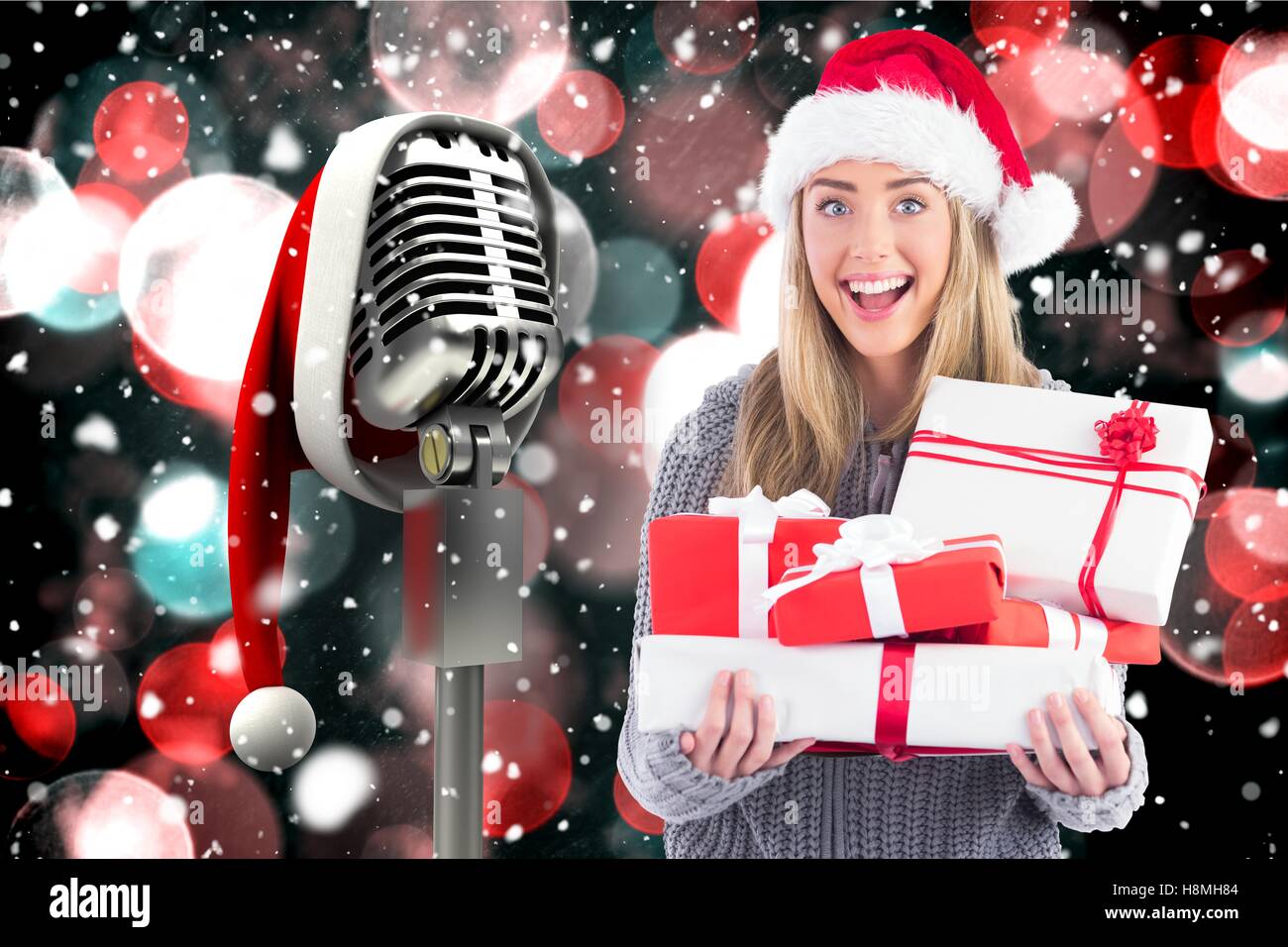 Excited woman in santa hat holding stack of gifts Stock Photo