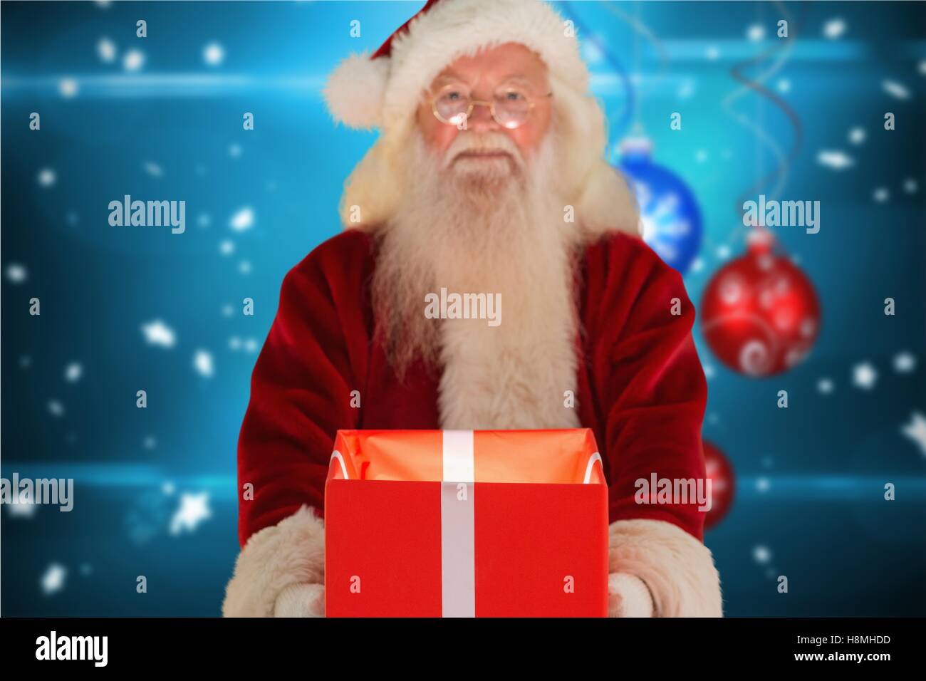 Santa claus holding a gift box Stock Photo - Alamy