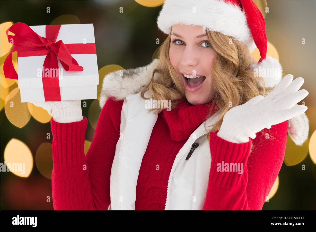 Excited beautiful woman in santa costume holding a gift Stock Photo