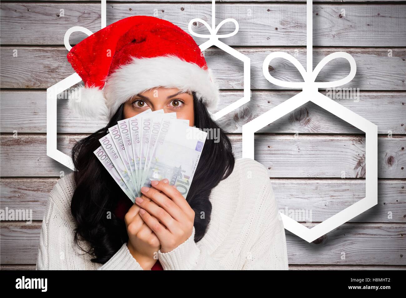Beautiful woman in santa hat holding currency note Stock Photo